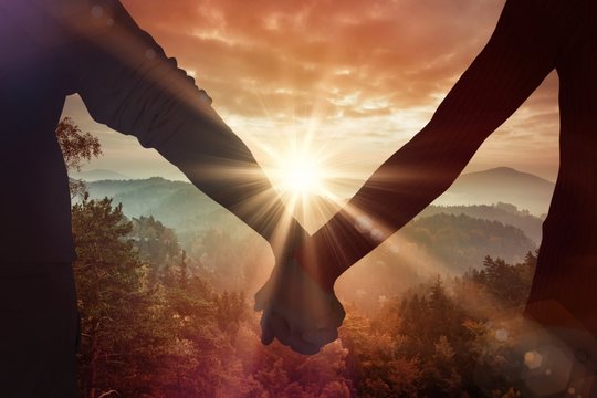 Hand holding over a sunset in nature